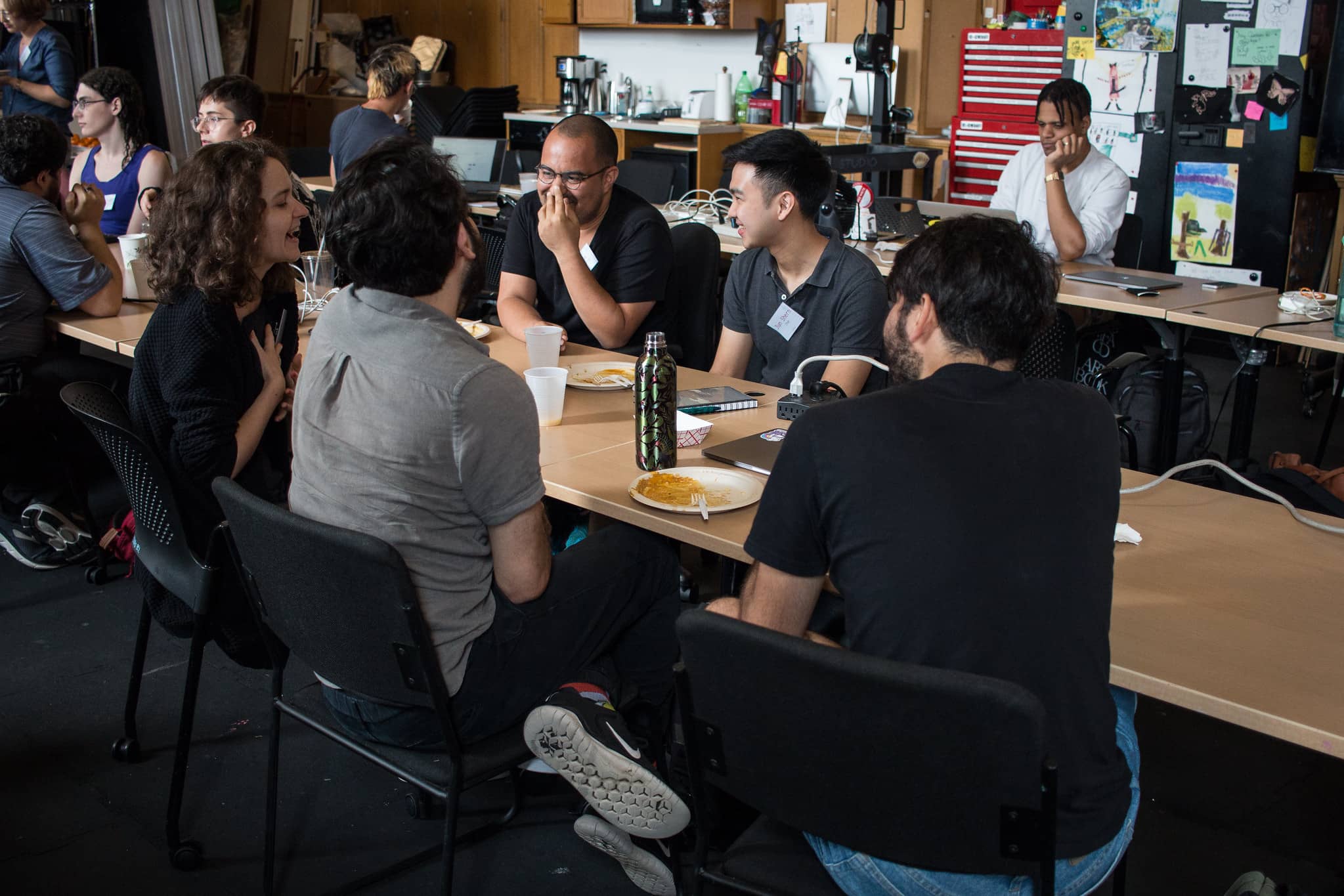 Participants sitting at a long table having lunch and a discussion"