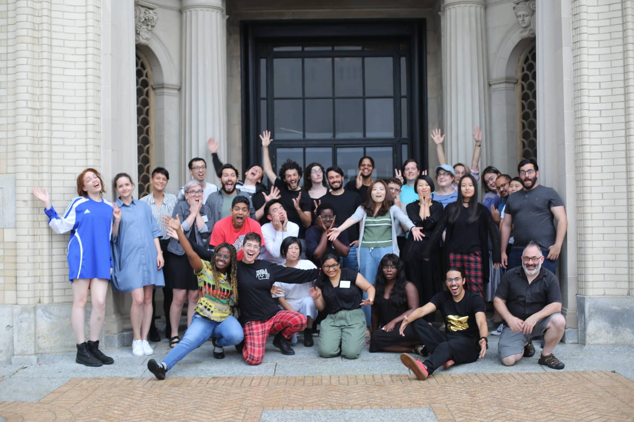 Group photo of participants smiling enthusiastically with their hands in the air"